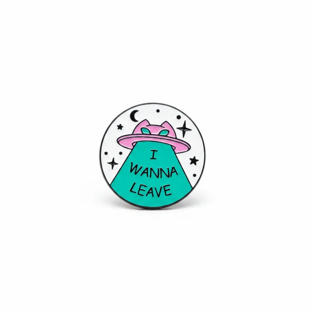 Century Fancy Beads round enamel brooch featuring a pink UFO and teal I WANNA LEAVE text on a white background